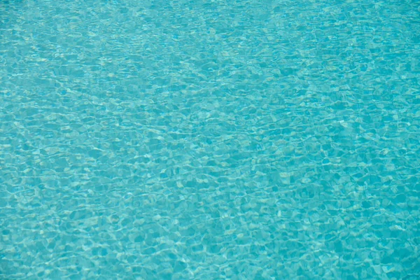 Yüzme havuzunda güneş yansımalı dalgalı su. Dalgalı su arkaplanı.