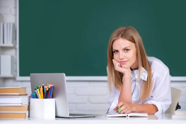 Retrato de una estudiante universitaria que estudia en la escuela o universidad. Concepto de educación estudiantil. Chica sonriente o retrato del profesor en el fondo de pizarra. — Foto de Stock