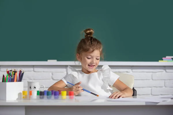 Małe dziewczynki rysują kolorowe obrazki kredkami ołówkowymi w klasie szkolnej. Maluję dzieci. Cute girl szkoły rysunek w klasie w szkole. — Zdjęcie stockowe