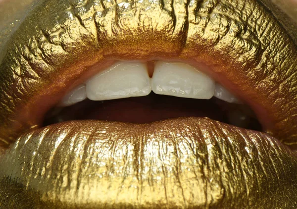 Kosmetyk. Złote usta. Złota farba z ust. Złote usta na ustach kobiety z makijażem. Zmysłowy i kreatywny design dla złotego metalu. — Zdjęcie stockowe