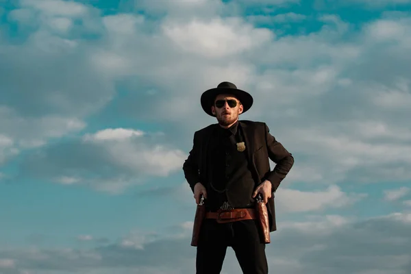 Sheriff o alguacil en el cielo. Oeste americano, salvaje oeste con vaquero. Tipo serio con arma de revólver al aire libre. — Foto de Stock