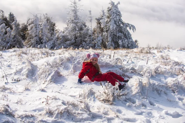 Χειμερινή παιδική ηλικία. Αξιολάτρευτο κοριτσάκι που διασκεδάζει τη χειμωνιάτικη μέρα. Χαριτωμένο κορίτσι ξαπλωμένο στο χιόνι — Φωτογραφία Αρχείου