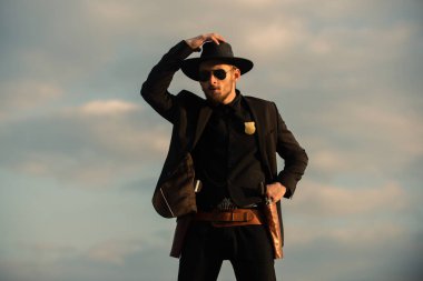 Kovboy şapkalı bir kovboy. Vahşi batı silahları, eski tabanca tabancası ve federal mühimmatı olan ciddi bir adam. Amerikan batı şerifi. Vahşi batı konsepti.