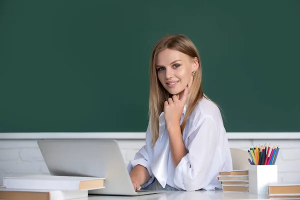 女子大生は教室のノートパソコンで働き、試験の準備をしています。カメラを見る陽気な大学生の肖像. — ストック写真