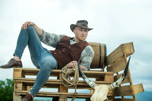 Cowboy a farmon. Jóképű férfi cowboy kalapban és retro vintage ruhában. Férfi retro divat, vintage divat, brutális férfi modell. — Stock Fotó