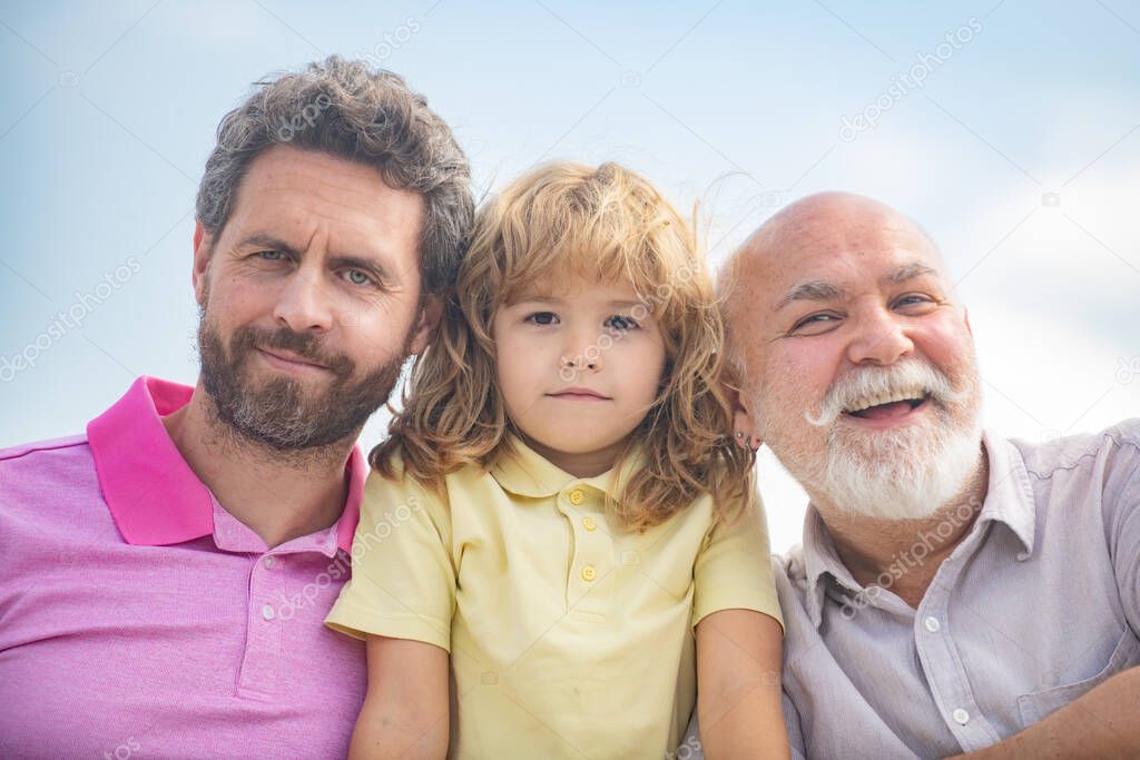 Boy son with father and grandfather, outdoor close up portrait. Fathers day. Men in different ages.