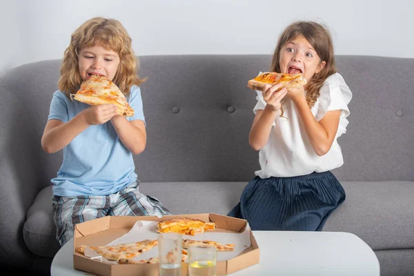 Funny cute children girl and boy eating tasty pizza. Hungry children eating pizza. — Stock Photo, Image