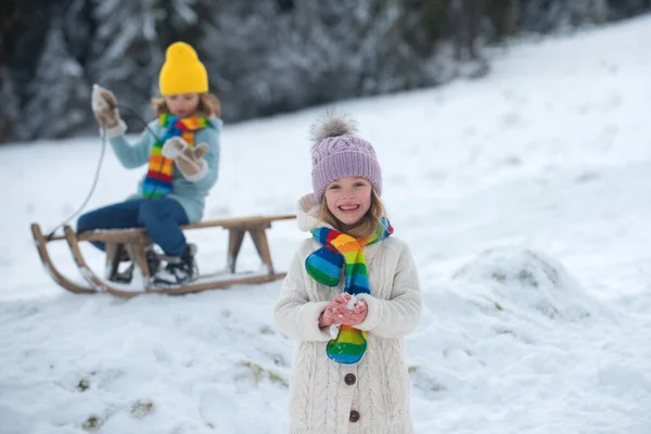 Drôle excité visage enfant fille dans la neige en hiver en plein air. Enfants en hiver en plein air dans le gel journée enneigée. Enfant étonnant se reposant ensemble dans le parc avec fond d'hiver. Des émotions expressives pour les enfants. — Photo