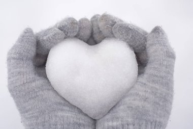 Karların kalbi. Kardan kalp ellerinde. Kar altyapısı karlı olan eldivenli insan elleri. Kışı ya da Sevgililer Günü 'nü seviyorum. Romantik yaratıcı kavram..