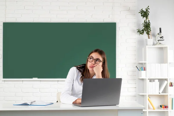女子大生は教室のノートパソコンで働き、試験の準備をしています。学校でのオンライン学習、遠隔教育. — ストック写真