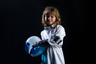 Uzay kıyafetli küçük astronot çocuk elinde siyah kaskla.