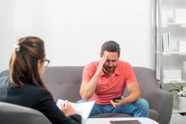 Psikiyatrist ile terapi seansı sırasında psikolojik sorunlarını tartışan bir adam. Sosyal Hizmetler Danışmanı.