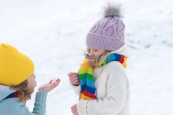 Enfants mignons garçon et fille jouant sur une promenade d'hiver dans la nature. Portrait de petits enfants heureux portant des vêtements d'hiver tricot chapeau. — Photo