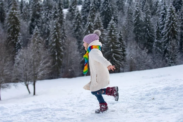 Funny excited child girl running in snow on winter outdoor. Children in winter outdoor in frost snowy day. — Stock Photo, Image