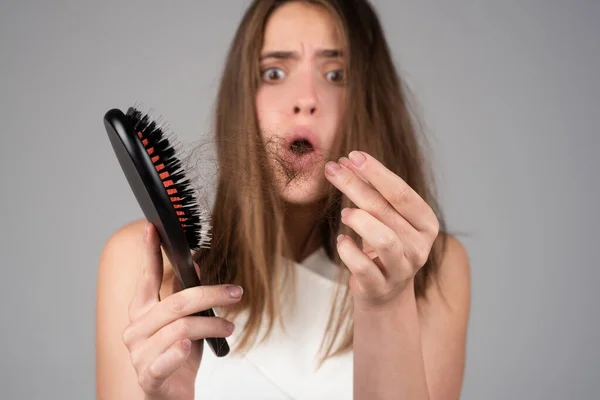 Chica triste mirando el cabello dañado, el problema de la pérdida de cabello. Espacio aislado, copia. — Foto de Stock