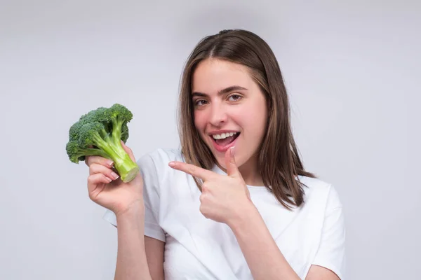 表现出花椰菜的女人健康的食物健康的生活生的食物概念。女人的手拿着一束花椰菜，盖在浅灰的背景上。关闭的脸，隔离与复制空间. — 图库照片