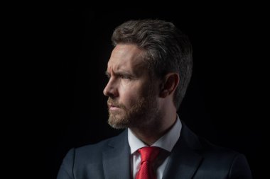 Siyah arka planda takım elbiseli başarılı orta yaşlı iş adamının portresi. Kendine güvenen bir iş adamı. Olgun iş adamı gibi düşün, yakından bak..