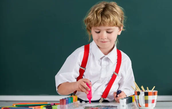 Portrait Schulkind Junge macht Kunst Hausaufgaben, hält Bleistift, schreibt. Junge beim Zeichnen in der Grundschule. Kinder Kunst, Kreativität Kinder. — Stockfoto