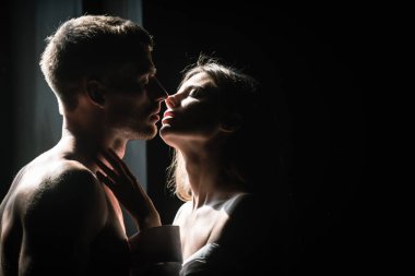 Tutkulu bir öpücük. Birbirine aşık güzel bir çiftin portresi. Genç şehvetli kız arkadaşı, erkek arkadaşından tutkulu bir öpücük aldığı için mutlu. Yakışıklı adam kadınını kucaklıyor ve öpüyor..