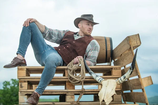 Um cowboy a usar chapéu. A vida ocidental. Bonito fazendeiro barbudo ocidental. Retrato de homem cowboy ou agricultor. Ocidental. Homens moda retro, moda vintage, modelo masculino brutal. — Fotografia de Stock