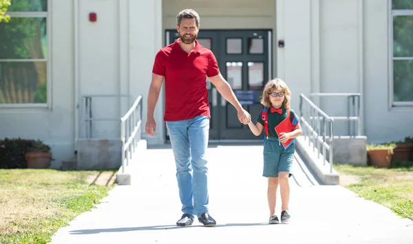 Açık hava okulu. Okullu çocuk babamla aynı okula gidiyor. Okul kapısının önünde çocuklu bir ebeveyn.