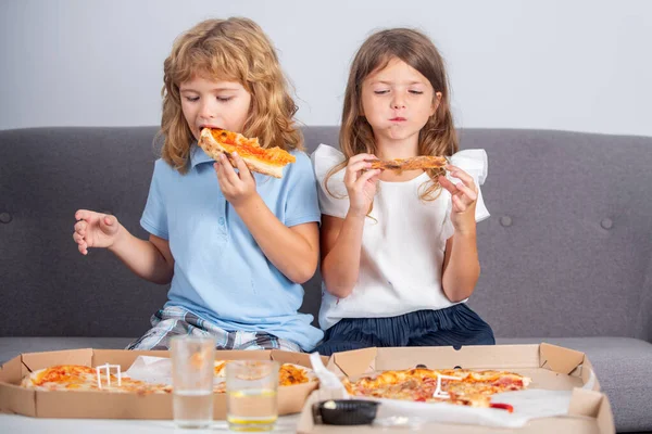 Little girl and boy eat pizza. Hungry children eating pizza. Unhealthy fast food. — Stock Photo, Image