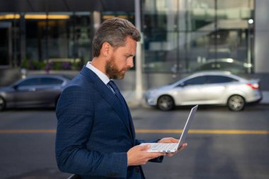 Dışarıda defter tutan bir iş adamı. Kendine güvenen bir iş uzmanı. Ofis geçmişinde dizüstü bilgisayarı olan yakışıklı bir adam..
