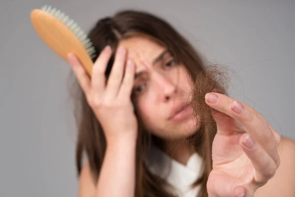Kobieta z problemem wypadania włosów. Portret młodej dziewczyny z łysiną. Zdjęcie nerwowej dziewczyny ze szczotką do włosów. — Zdjęcie stockowe