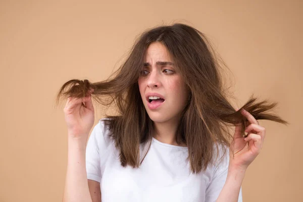 Chica triste mirando el cabello dañado, el problema de la pérdida de cabello. Espacio aislado, copia. —  Fotos de Stock