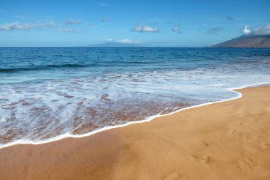 Kumlu sahilde mavi okyanus dalgası. Yaz mevsiminde gün batımında plaj. Plaj manzarası. Tropik deniz manzarası, sakinlik, dinlendirici güneş ışığı.
