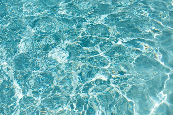 Wasserhintergrund, wogende Wellen. Blaues Schwimmbadmuster. Meeresoberfläche. Wasser im Schwimmbad mit Sonnenreflexion. Banner mit Kopierraum. — Stockfoto