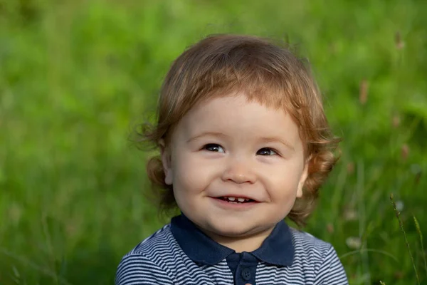 Lifestyle portret baby kind in gebeurt aan de buitenkant in de wei. Baby gezicht van dichtbij. Grappig kinderportret. Blond kind, emotie gezicht. — Stockfoto