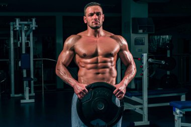 Spor salonundaki adam. Güç, güç ve sağlıklı yaşam tarzı, spor. Güçlü, çekici, kaslı adam antrenörü spor salonunda çalışıyor..