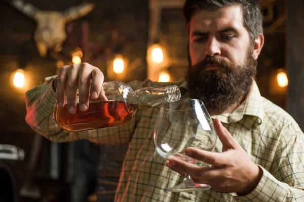 Ochutnávka drahé whisky. Vousáč se sklenicí whisky. Mužský model pije brandy nebo koňak. Drahý nápoj. — Stock fotografie