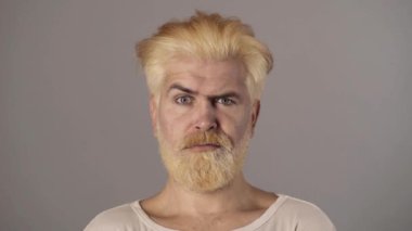 Yüz ifadesi olan komik, komik, sarışın adam. İnsani duygular, komik suratlı hipster. Erkek saçı.