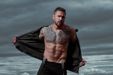 Kendine güvenen, çekici, seksi adam. Deri ceketli, modacı erkek model..