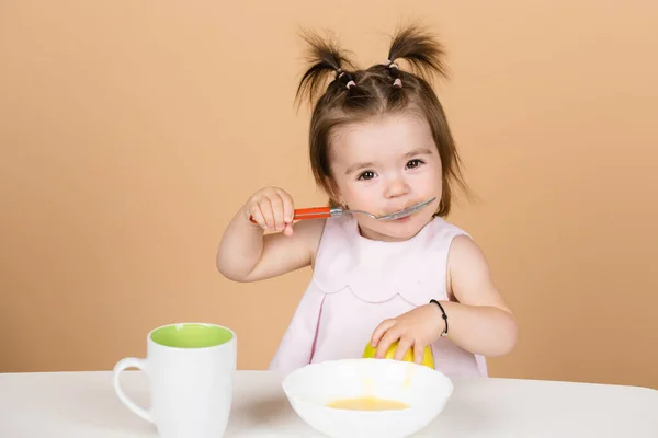 Baby 's eten, gezond voedsel voor een baby. Kleine baby die fruitpuree eet. — Stockfoto