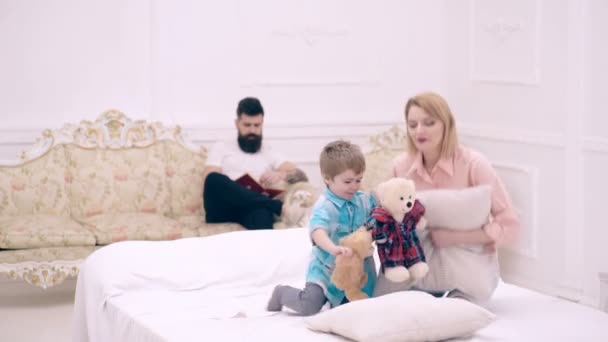 Anne baba ve çocuk yatakta oynuyorlar. Aile harika hafta sonu konsepti. — Stok video