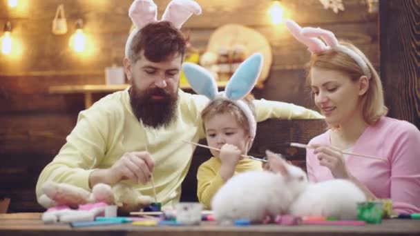 Familia de Pascua de madre, padre e hijo hijo pintaron huevos, usando orejas de conejo. Familia Celebrando la Pascua con los niños en casa, Divertidos conejos de Pascua padres. Tiempo libre familiar. — Vídeos de Stock