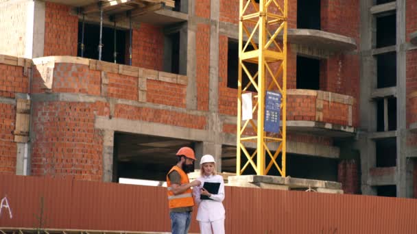 Successful architect at a building site. Workers talking and laughing at a factory. — Stockvideo