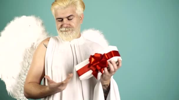Божевільний ангел-купідон з подарунком. Кумедний бородатий чоловік з пір'ям крил день Купідона Валентинів. Гумористична концепція. — стокове відео