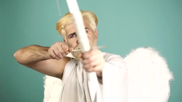 Funny cupid, handsome guy on valentine day with bow arrow shooting. Love concept. Handsome crazy fun angel. Valentines Day. — Stockvideo
