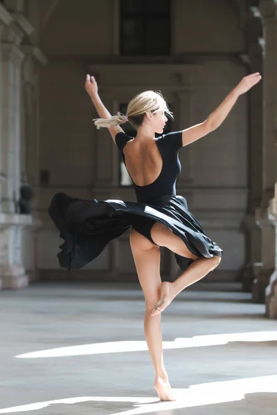 Street style photo of elegant fashionable woman movement in skirt. Sexy black dress. Sensual woman dancing outside, ballerina dance in black dress. — 图库照片