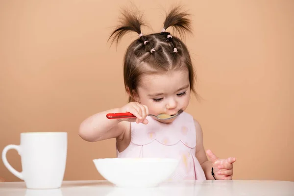 Los niños comen una nutrición saludable, comida para bebés. Bebés comiendo con cuchara. Lamer sabrosa cuchara. Retrato de niño caucásico lindo con cuchara. Bebé desordenado hambriento con plato después de comer puré. — Foto de Stock