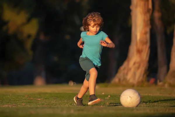 Chłopiec kopie piłkę nożną na boisku podczas meczu piłki nożnej. Młode sportowe dzieci. — Zdjęcie stockowe