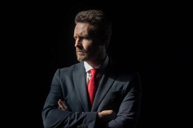 Siyah üzerine izole edilmiş zarif yakışıklı bir iş adamının portresi. Yakışıklı, orta yaşlı, takım elbiseli bir işadamı fotokopi alanı olan siyah bir arka plana karşı poz veriyor. Olgun iş adamı.