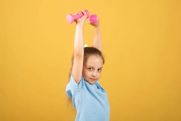 Sporty girl with dumbbells. Fitness kids, health and energy. Healthy kids lifestyle. Kid exercising with dumbbell. Sport for little children. Sport portrait kids. — Stockfoto