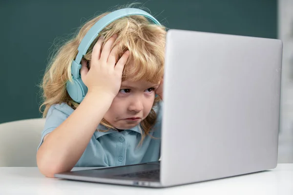 Angry sad school kid working in computer class. Little funny system administrator or programmer. — Fotografia de Stock