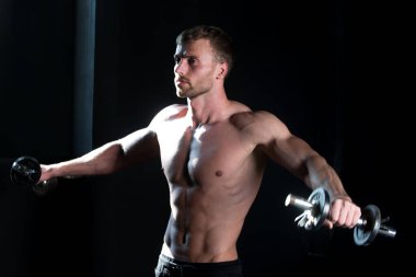 Sportif gövde, dambılı adam. Kaslı adam yaya geçidinde. Stüdyoda çalışan genç adam. Sporcu adam egzersiz yapıyor..