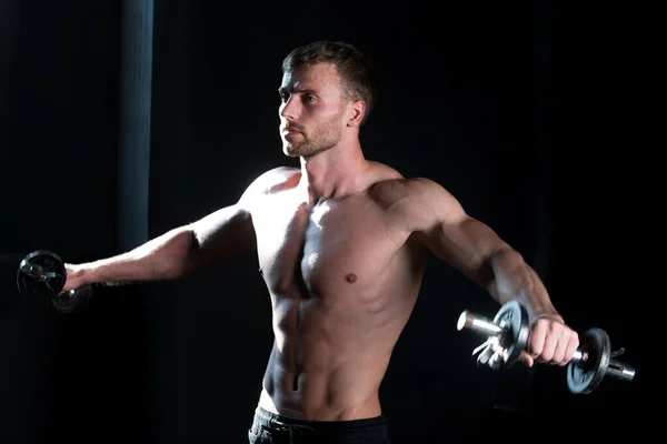 Sportlicher Oberkörper, Mann mit Hanteln. Muskelkräftiger Mann beim Crossfit. Junger Mann beim Training im Studio. Athletischer Typ beim Sport. — Stockfoto